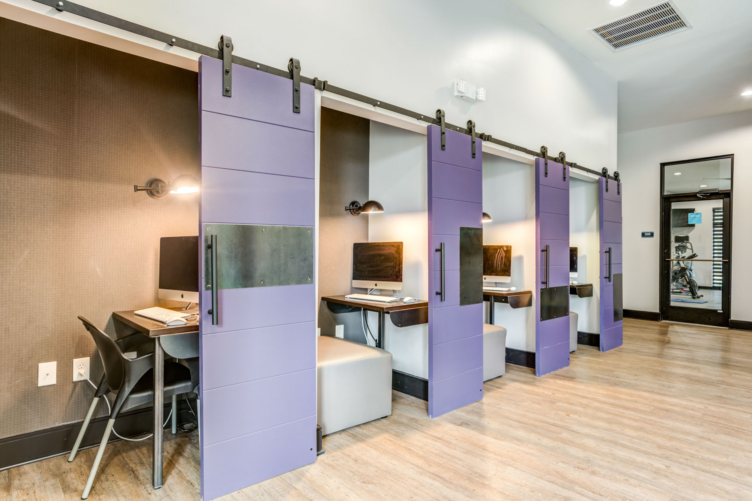 Individual study rooms with desks and computers