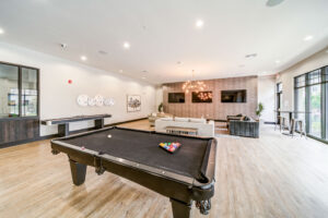 Resident clubroom with pool table seating and TVs